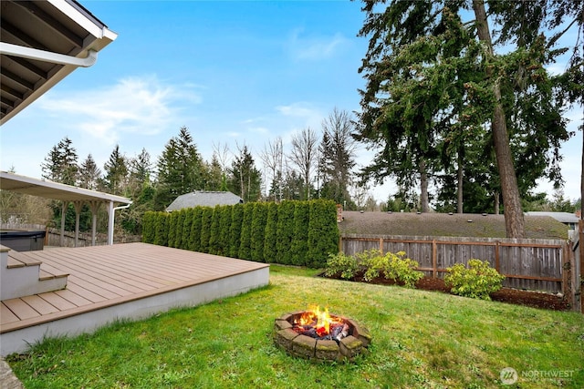 view of yard with a fire pit, a wooden deck, and fence