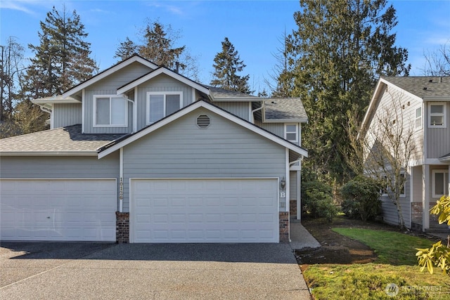 view of front of property featuring driveway and a shingled roof