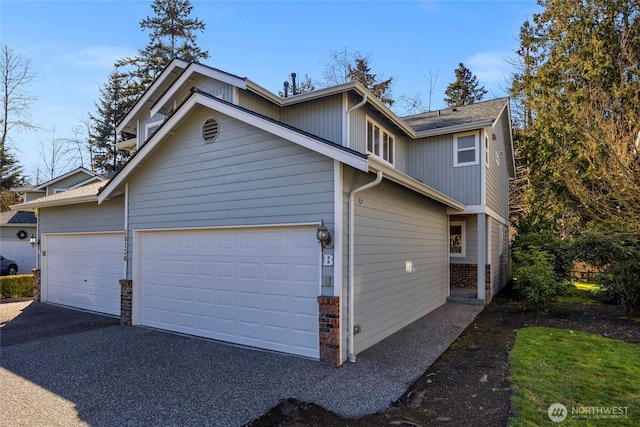 view of side of home featuring a garage and driveway