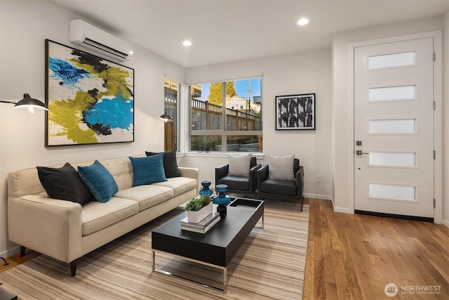 living area with recessed lighting, an AC wall unit, light wood-style flooring, and baseboards