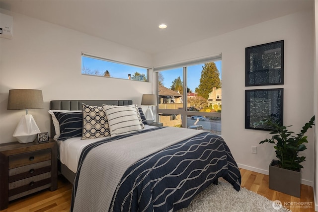 bedroom with recessed lighting, wood finished floors, and baseboards