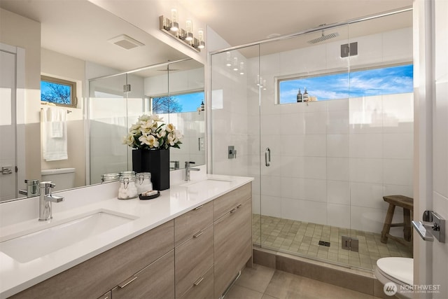 full bathroom featuring toilet, visible vents, and a sink