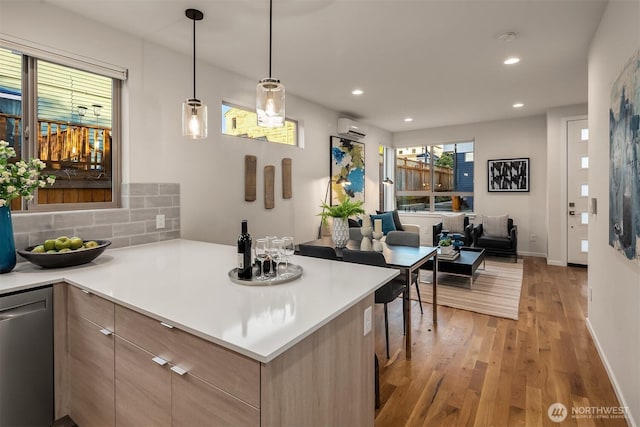 kitchen with dishwasher, light countertops, light brown cabinetry, light wood-type flooring, and backsplash