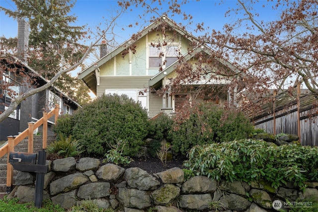 view of home's exterior with a garage, a chimney, and fence