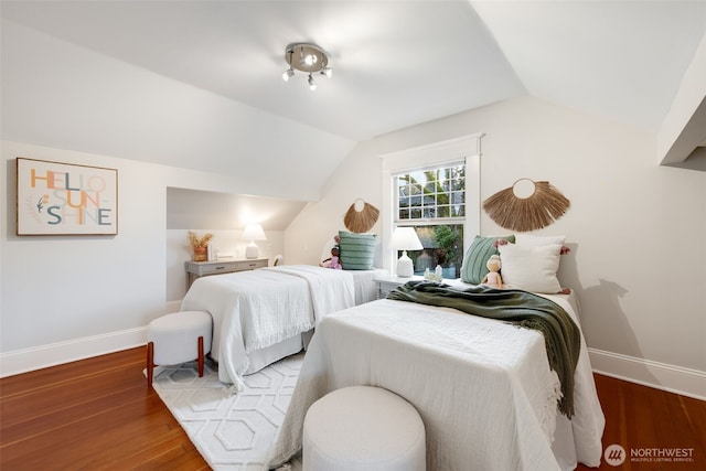 bedroom featuring baseboards, vaulted ceiling, and wood finished floors