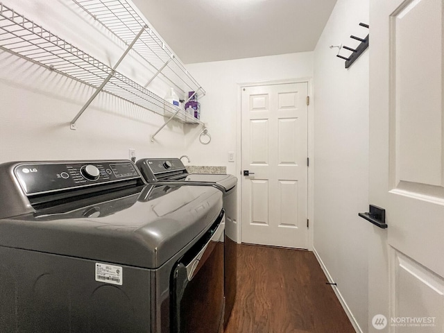 washroom with baseboards, laundry area, dark wood-type flooring, and washer and dryer