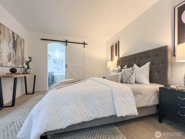 bedroom featuring carpet, connected bathroom, and a barn door