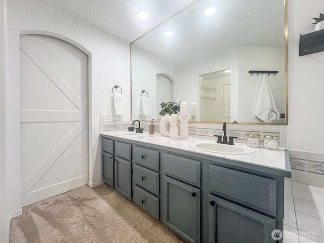 full bathroom featuring double vanity, a sink, and recessed lighting