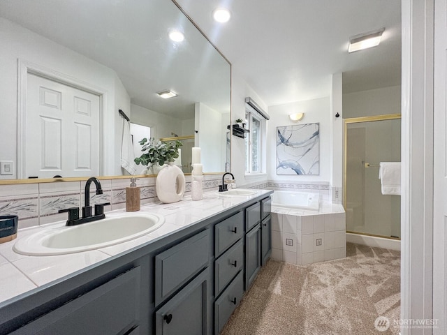 bathroom featuring a stall shower, a garden tub, a sink, and double vanity