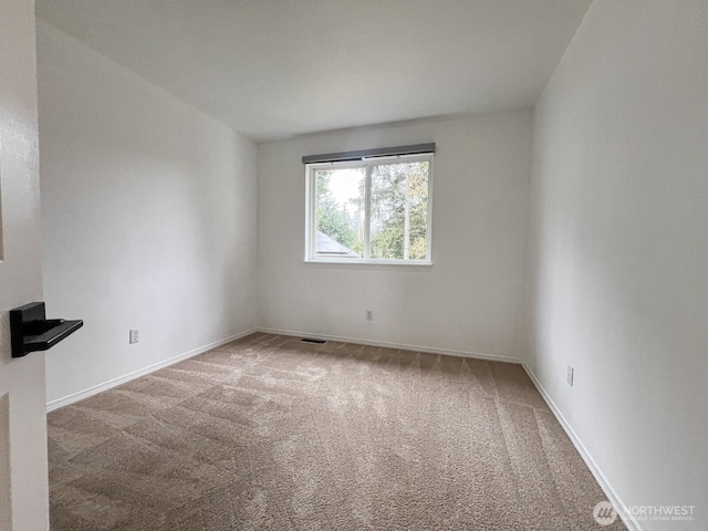 carpeted empty room with visible vents and baseboards