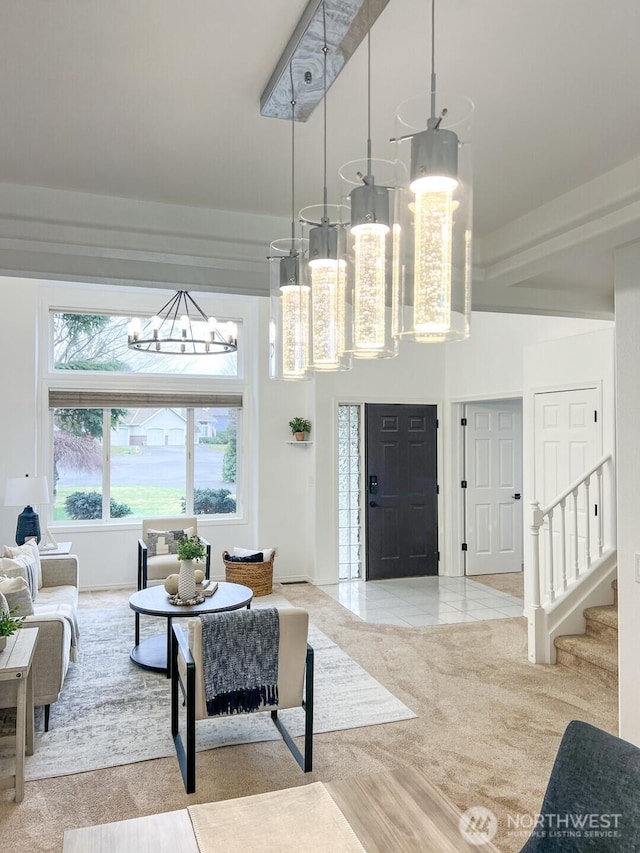 foyer entrance featuring a chandelier, a high ceiling, carpet flooring, stairs, and tile patterned floors