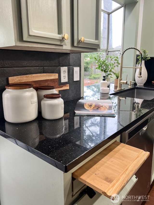 interior details with decorative backsplash, a sink, and dishwashing machine