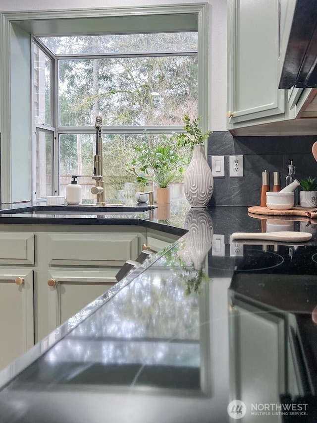 kitchen featuring dark countertops, white cabinetry, and backsplash