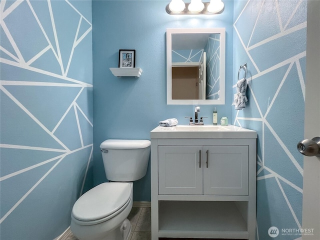 bathroom featuring tile patterned floors, baseboards, toilet, and vanity