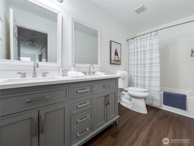 full bathroom featuring double vanity, toilet, visible vents, and a sink