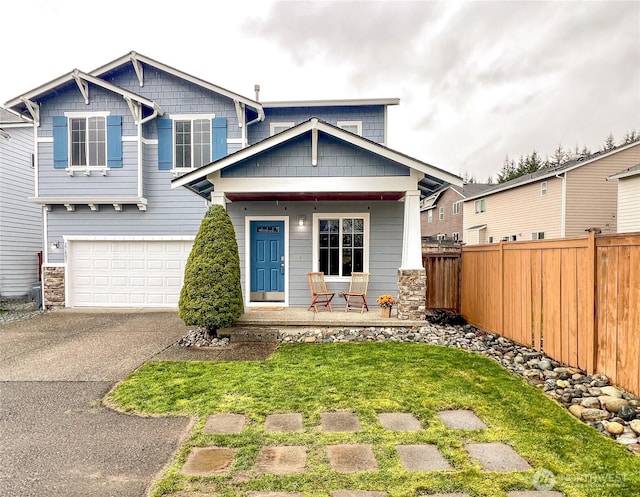 craftsman inspired home featuring covered porch, concrete driveway, a garage, and fence