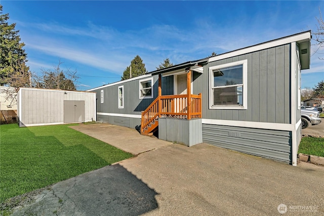 view of front facade featuring an outbuilding, a front lawn, and a shed