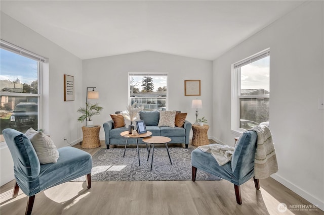 sitting room with baseboards, vaulted ceiling, a wealth of natural light, and wood finished floors