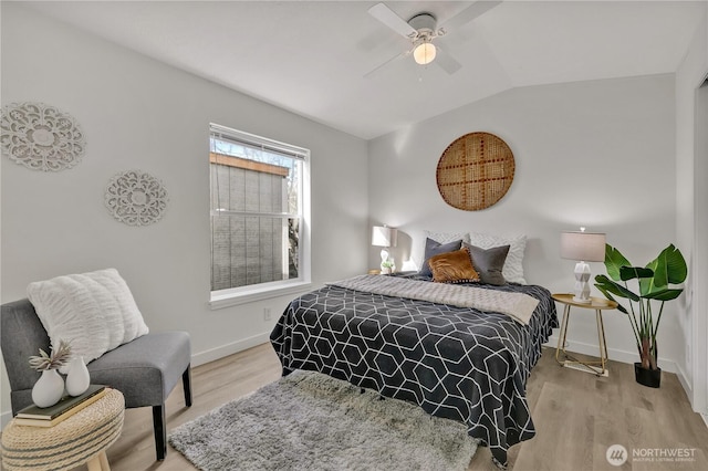 bedroom with light wood-style floors, vaulted ceiling, baseboards, and ceiling fan