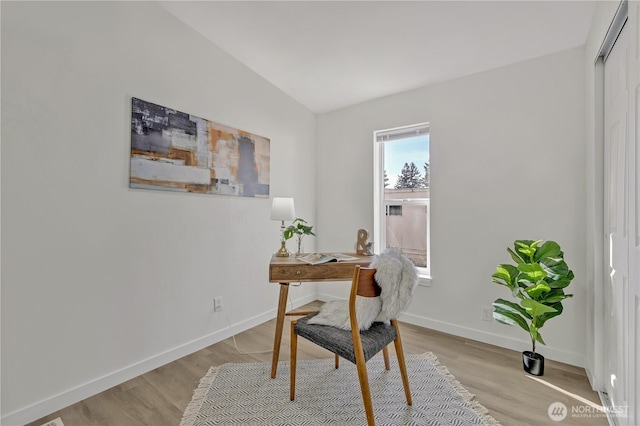 home office with lofted ceiling, light wood-style flooring, and baseboards