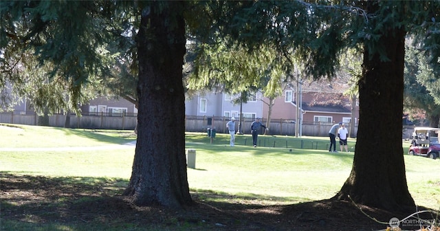 view of home's community with fence and a yard