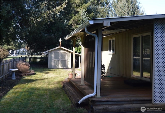 view of yard featuring an outbuilding, fence, a wooden deck, and a storage shed