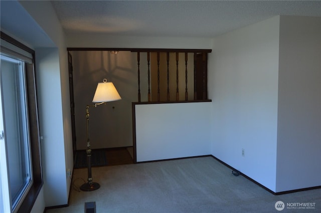 carpeted spare room featuring visible vents and baseboards