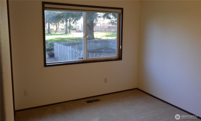 empty room featuring carpet, visible vents, and baseboards