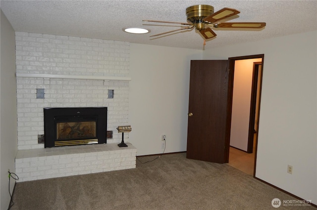 unfurnished living room with carpet floors, a fireplace, a ceiling fan, a textured ceiling, and baseboards