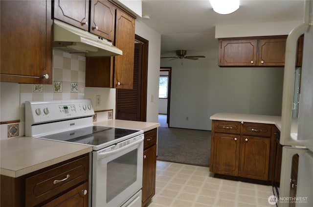 kitchen featuring white appliances, under cabinet range hood, light countertops, and a ceiling fan