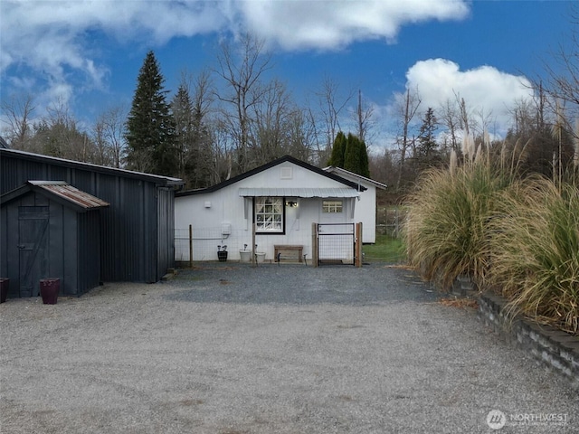 view of outbuilding with an outbuilding, fence, and a gate