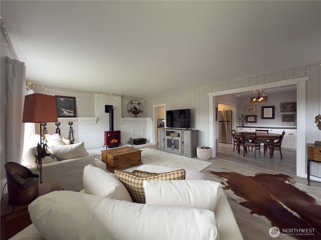 living area with a wood stove and wood finished floors