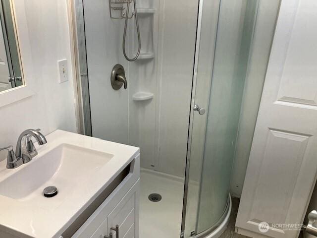 bathroom featuring a shower stall and vanity