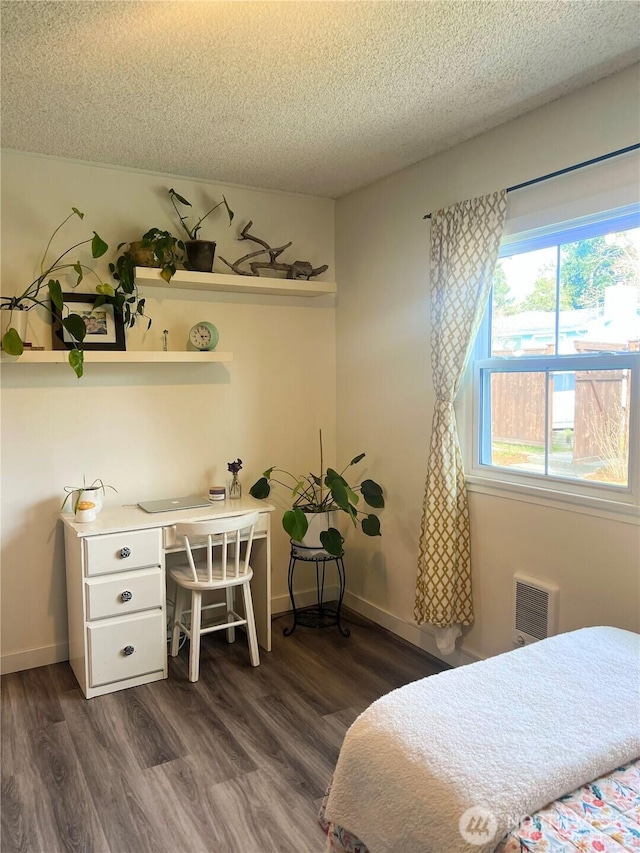 bedroom featuring baseboards, a textured ceiling, and dark wood-style flooring