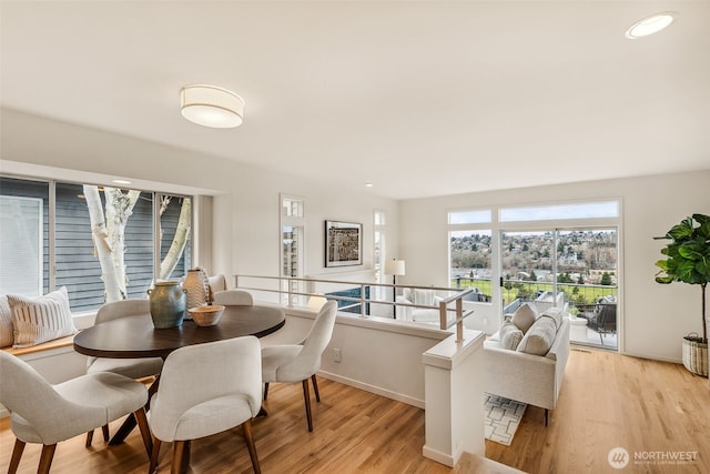 dining space with baseboards, recessed lighting, and light wood-style floors