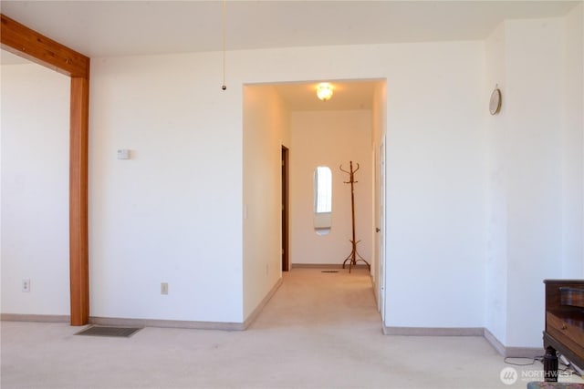 interior space with light carpet and baseboards