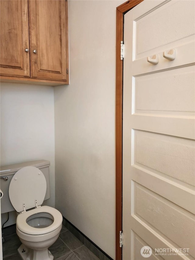 bathroom featuring toilet and baseboards