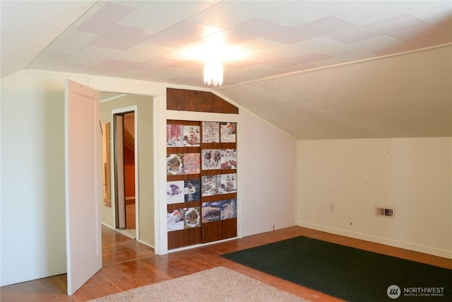 bonus room featuring visible vents, vaulted ceiling, and wood finished floors