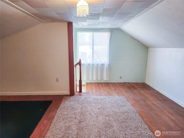 additional living space featuring vaulted ceiling, wood finished floors, and baseboards