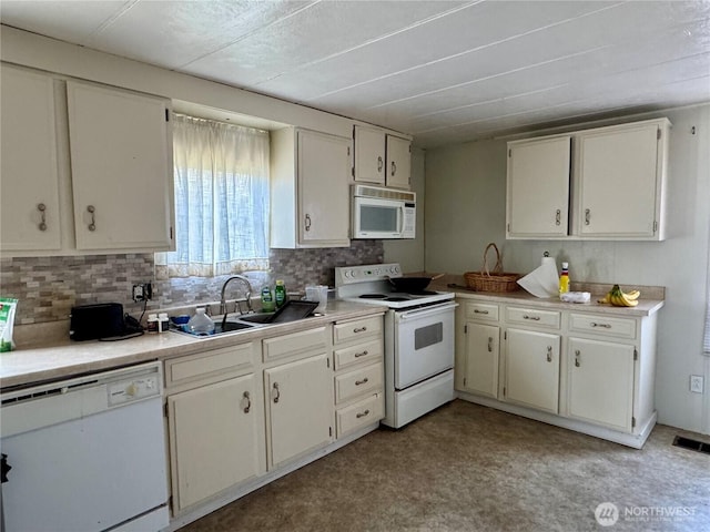 kitchen featuring white appliances, a sink, visible vents, light countertops, and backsplash