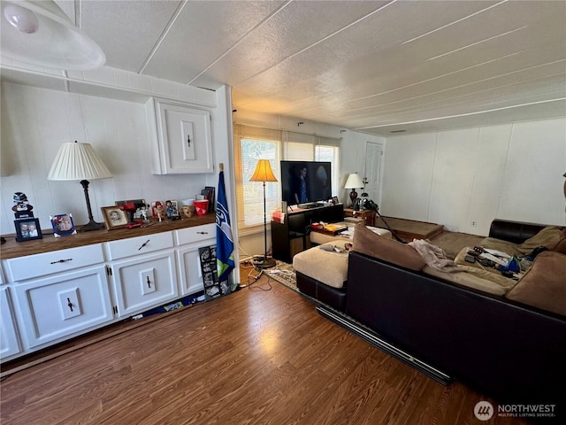 living area featuring dark wood finished floors and a decorative wall