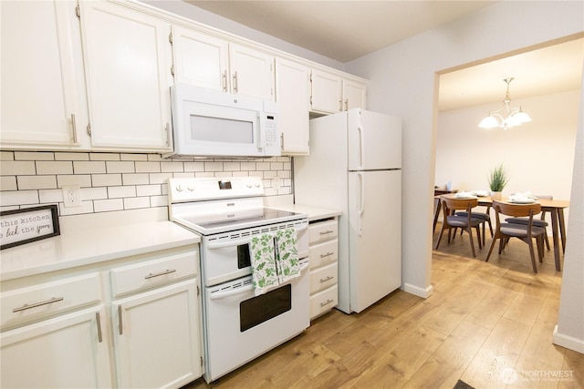 kitchen with white appliances, white cabinets, light countertops, light wood-type flooring, and decorative backsplash