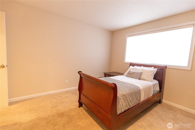 bedroom with light carpet and baseboards