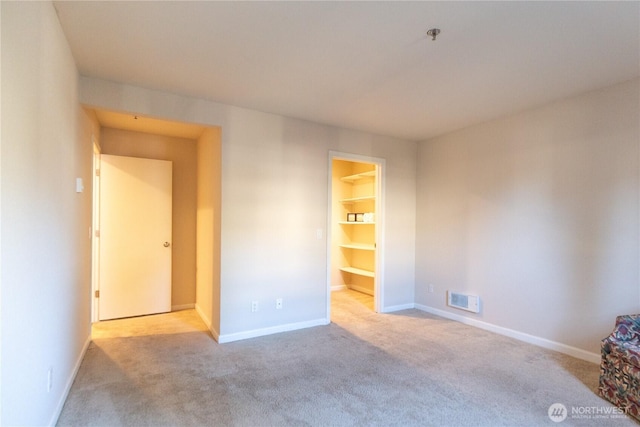 unfurnished bedroom with carpet, visible vents, and baseboards