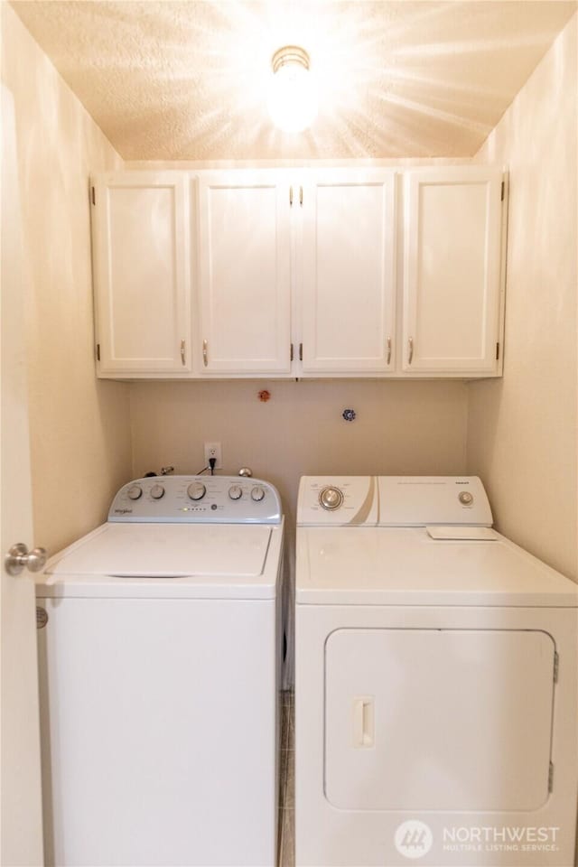 washroom featuring washer and clothes dryer and cabinet space