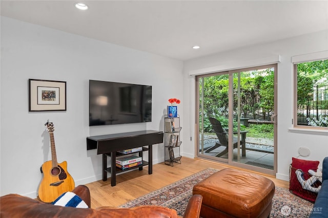 living area with baseboards, wood finished floors, and recessed lighting