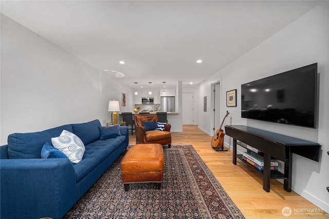 living room featuring light wood-style floors, recessed lighting, and baseboards