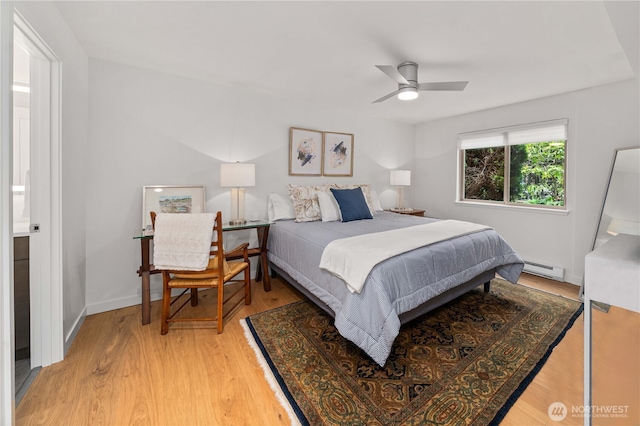 bedroom featuring light wood finished floors, baseboards, a baseboard heating unit, and ceiling fan