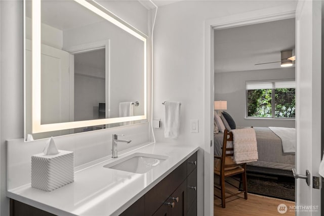 bathroom featuring vanity, a ceiling fan, wood finished floors, and ensuite bathroom