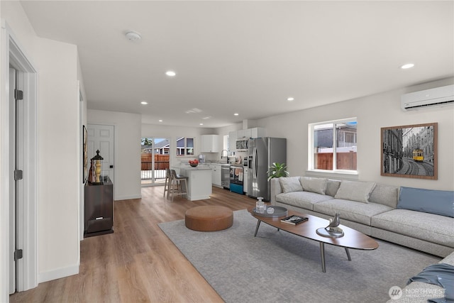 living room featuring light wood-style floors, recessed lighting, and a wall mounted air conditioner